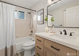 Full hall bath with modern vanity and quartz countertop on the upper level.