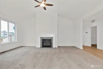 Living /great room with cozy fireplace with tile surround. Ceiling fan included. Photo for illustration only of similar home, not actual.