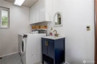 Laundry room has abundant storage & 1/2 bath.