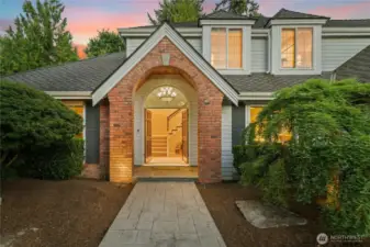 Gorgeous front entry with stamped concrete and brick arch way.