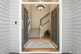Double door entry with vaulted ceilings and main staircase.