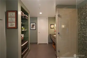 A spacious bathroom with walk-in closet thru white door.