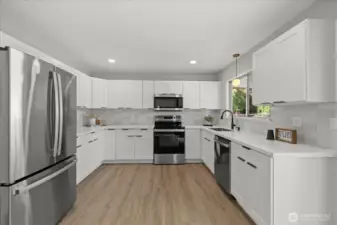 Stunning remodeled kitchen with quartz countertops, tile backsplash, and stainless steel appliances