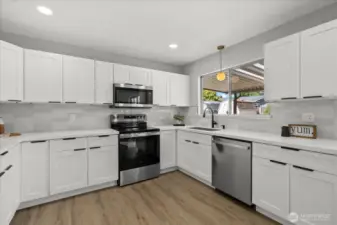 Crisp white shaker cabinets and stylish tile backsplash elevate the kitchen