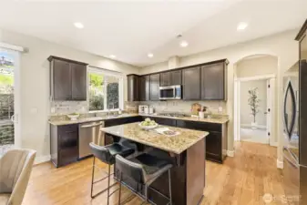 This kitchen truly has it all - a gas cooktop, stainless steel appliances, large prep island, and tons of cabinet space