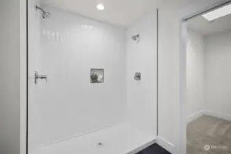 Double shower heads with tile surround and glass door.