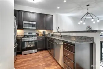 Chef's Kitchen w/ SS appliances, granite counters, custom cabinetry.