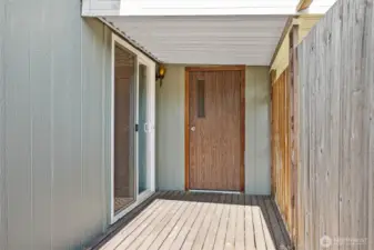 View of private deck off of primary bedroom & storage room door.