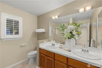 Primary bath featuring dual vanities and tiled floor