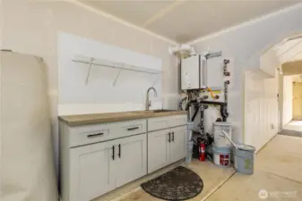 Full sink next to the tankless water heater in the garage.