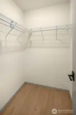 Generous walk-in closet space featuring built-in wire shelving for easy organization.
