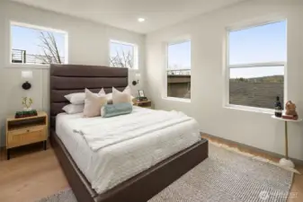 Spacious primary bedroom featuring expansive windows with territorial views and a sophisticated neutral color palette.