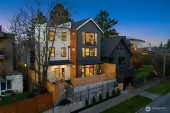Striking twilight view of the home’s contemporary architecture, featuring high-end siding, professional landscaping, and inviting exterior lighting.