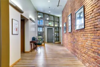Step into the secure lobby where exposed brick, metal accents, weathered wood, and a neutral palette define classic industrial style. The elevator ahead makes coming and going effortless—let’s head upstairs!