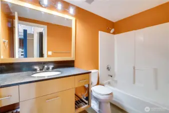 The well-appointed bathroom features a true bathtub, generous counter space, and low-maintenance flooring.