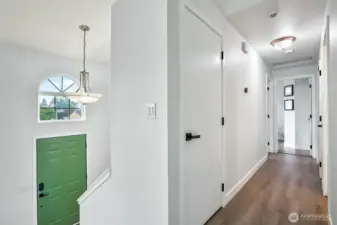 Upstairs hallway with modern light fixtures and updated doors. Arched window above front entry adds extra natural light.