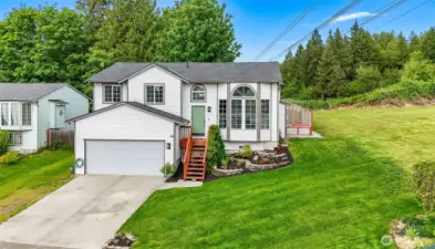 Crisp exterior with 2025 roof, fresh landscaping, and a green front door. Located on a spacious corner lot with side yard.