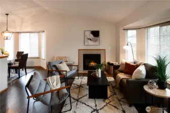 Bright, welcoming living room with cozy gas fireplace, large windows for natural light, and an open flow into the dining area — freshly inspected with most items already addressed for peace of mind.