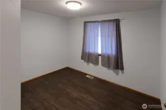 The 3rd of 3 bedrooms in this home has a window facing the back yard for privacy and a generous closet plus wood floor for easy cleaning.