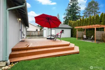 Expansive entertainment deck overlooking the fully fenced backyard, complete with detached shop/garage and covered pergola seating — a fantastic space for relaxing or hosting.
