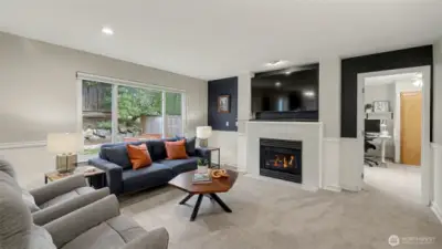The cozy family room features a gas fireplace. The den/potential 5th bedroom is through the doorway.