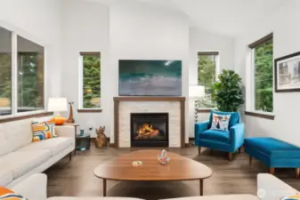 Open living area featuring vaulted ceilings and a cozy gas fireplace.