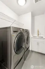 Spacious laundry room with a sink, washer and dryer included.