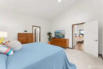 Spacious primary bedroom with vaulted ceilings, a walk-in closet, and an attached ensuite bath.