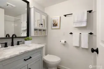 Updated bathroom with marble countertop and tile floors