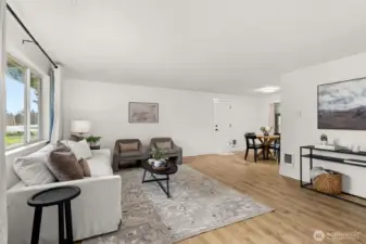 Great room with new flooring leading into dining area.