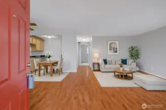 Step inside to a bright and open living space featuring warm flooring and a seamless flow into the kitchen.