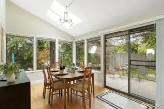 Dining area with sliders to backyard and walls of windows to bring the outside in.