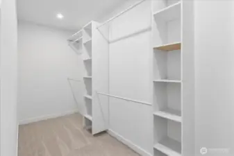 Huge walk in closet with built in cabinets.