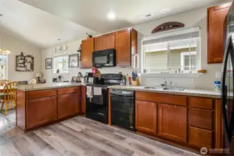 Beautifully appointed kitchen with beautiful black appliances, lots of counter space and cupboards, and luxury vinyl flooring.