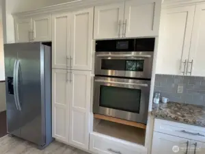 Soft close cabinets with pull out shelving and stainless steel appliances