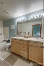 The primary bedroom suite is truly a retreat —offers a private en-suite bathroom that features dual sinks, a cabinet vanity, a large soaking tub, and shower.