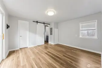 Master bedroom with walk-in closet and barn door leading to bathroom.