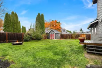 Nice fenced yard space with raised garden beds and storage shed