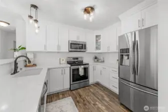 Remodeled kitchen with updated stainless steel appliances. Gorgeous quartz countertops, quality cabinets and updated flooring!