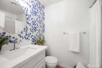 hall bathroom with updated cabinets and quartz countertops. The wallpaper is peel and stick and is easily removable.