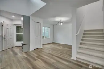 View of entry way to the left, main floor flex space and stairs to the upper level