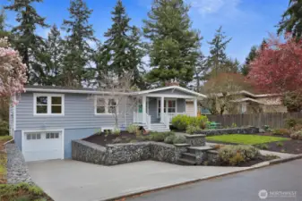 A widened and re-poured driveway with permitted drain, fresh paint on cedar siding, and thoughtful landscaping make for ideal curb appeal.