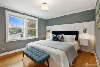 Southeast-facing primary with dimmable lighting, custom wainscoting, and great morning light. (Lights and side tables stay with the home).