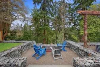Sturdy, attractive gabion walls create a cozy private fire pit area, looking out to peaceful green views. (There's also built-in lighting here for gatherings that go late!)