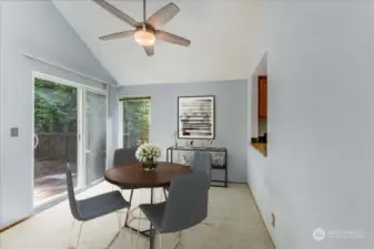 Dining area with slider leading to rear deck. Photo virtually staged