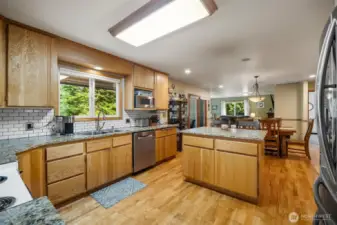 Welcome into the spacious kitchen with solid oak cabinets and slab granite counters and an island with an eating bar.