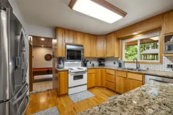 The electric range has a double oven and the seller loves it! There is a beautiful tile backsplash and an abundance of cabinet storage and counter space.