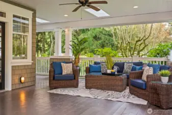 Twilight is best spent on the deep, covered veranda. With built-in speakers, recessed lighting, and a ceiling fan, it serves as a year-round outdoor living room overlooking the manicured grounds.