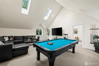 The expansive upper-level bonus room is the ultimate "party platform" for indoor leisure, featuring vaulted ceilings and ample space for a billiards table and media lounge.