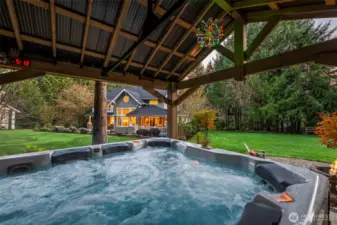 As evening falls, retreat to the stone fire pit or the hot tub gazebo. Framed by towering evergreens, this space defines the "comfortable luxury" of gated Fox Island living.